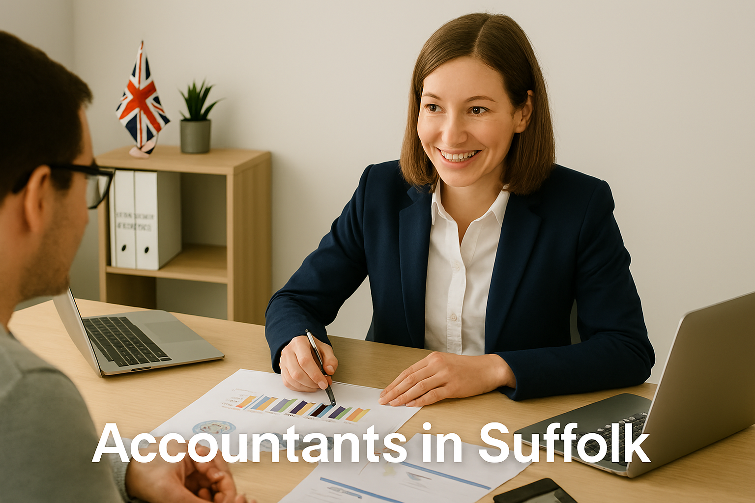 A professional accountant in a modern Suffolk office explains financial charts to a client across a tidy desk with a laptop, spreadsheets, and calculators. A small British flag and HMRC document in the background suggest a UK business setting. Overlay text reads Accountants in Suffolk